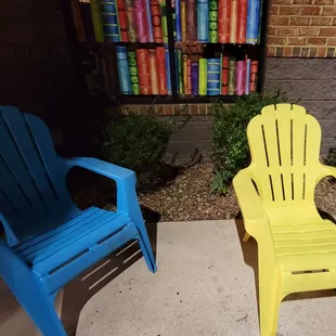 two plastic chairs in front of a bookshelf