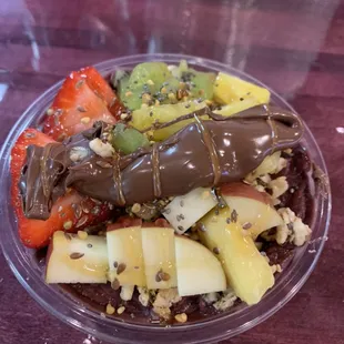 Acai topped with apple, kiwi, strawberry, granola, pineapple, Nutella, honey, and bee pollen.