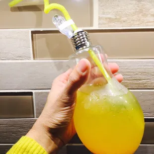 a person holding a glass of orange juice