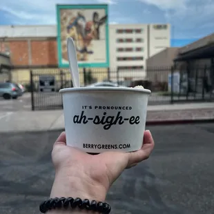 a hand holding a cup of ice cream