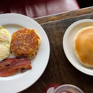 Eggs, hash browns, bacon, and pancakes