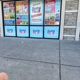 a woman sitting on the sidewalk in front of a store