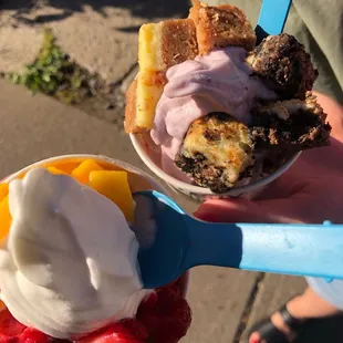 a person holding a bowl of ice cream and fruit