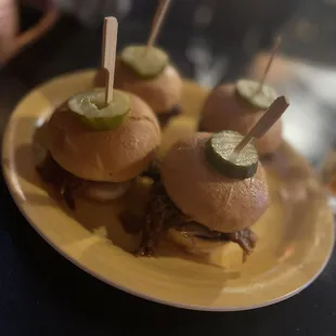 a plate of sliders with pickles