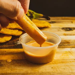 a person dipping a piece of bread into a bowl