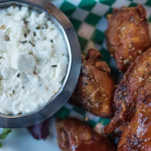 a plate of chicken wings with a side of rice