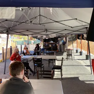 a man sitting under a tent
