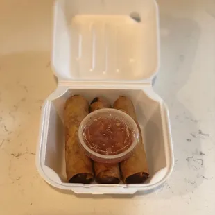 a takeout container with a dipping sauce
