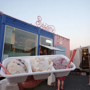 a hand holding a container of ice cream