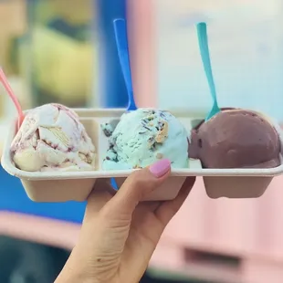 a hand holding a container of ice cream