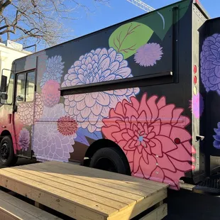 a food truck with flowers painted on it