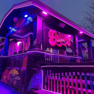 a purple neon sign on the front of a restaurant