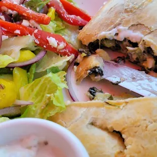 Mediterranean empanada with tzatziki sauce and Greek salad.