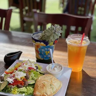 Spinach and cheese empanada with Mediterranean salad and tropical iced tea.