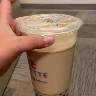 a hand holding a cup of bubble tea