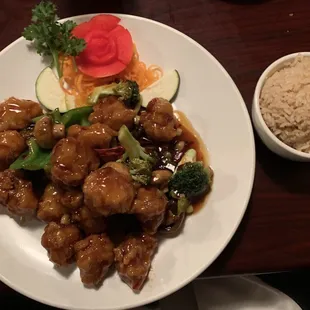 a plate of chinese food and a bowl of rice