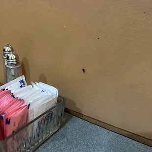 a container of tea bags and a salt and pepper shaker