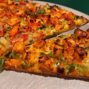 Closeup of thin crust Half and half pizza (chicken tandoori and shahi paneer)