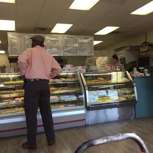 a man standing in front of a display of donuts