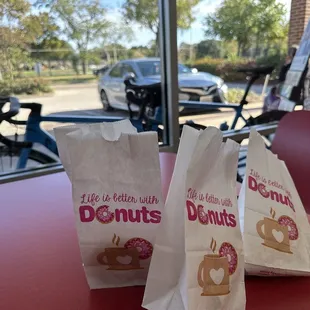 two bags of doughnuts on a table