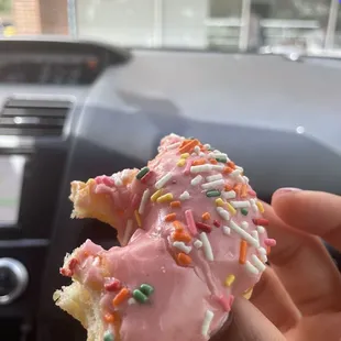 a pink frosted donut with sprinkles