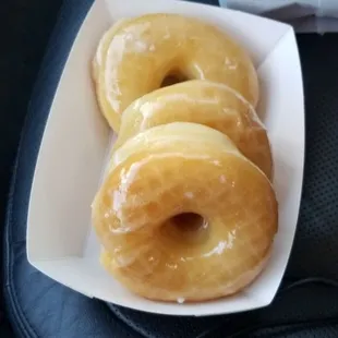 three glazed donuts on a white plate