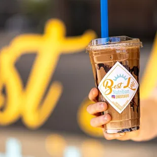 a hand holding a cup of iced coffee