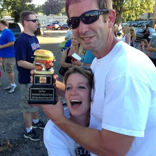 a man and a woman holding a trophy
