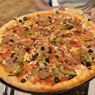 a person holding a large pizza