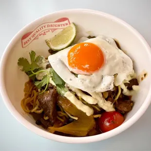 Curry guisada Dan Dan with Peeler Farms Wagyu beef, heirloom tomatoes, fermented black beans, salsa verde cremosa, and a fried egg