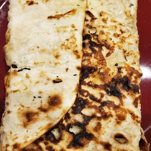 two quesadillas on a red plate