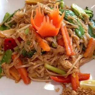 a plate of noodles with carrots and broccoli