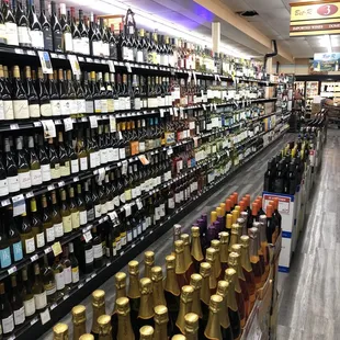 ows rows of bottles of wine on shelves