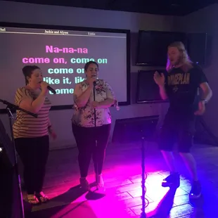 Two sisters sing a duet while another fun patron dances along!