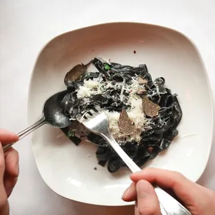 a plate of pasta with mushrooms and parmesan cheese