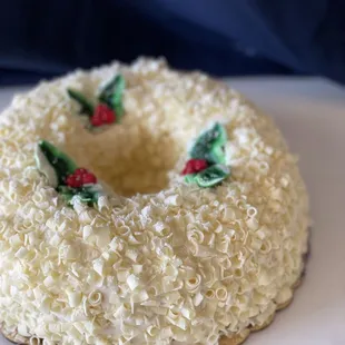 Wreath Cake - Yellow cake with Strawberry Buttercream filling, covered with French Buttercream and White Chocolate curls.