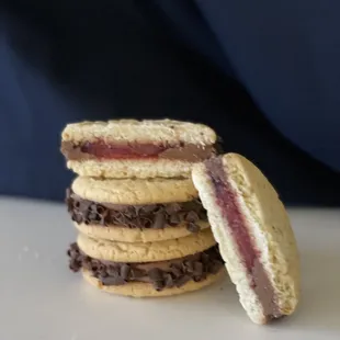 Cordial Cherry Cookie Sandwich - 2 sugar cookies, a ring of chocolate fudge, cherry pie filling, and decorated with chocolate shavings