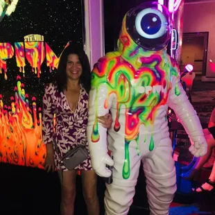 a woman standing next to an astronaut