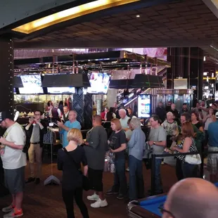 Athlete Richard Petty signing for a fan next to the billiards table.