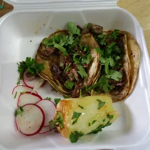 2 carne asada tacos with radish and a roasted Chile