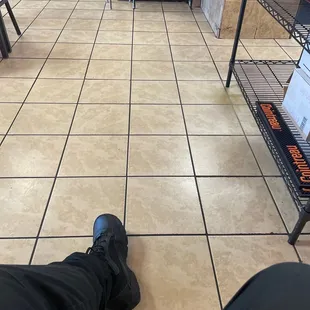 a person's feet on a tiled floor