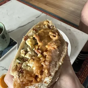 Half of a bacon breakfast burrito with one of their hot sauces. SO. GOOD.
