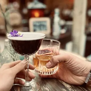 two people clinking glasses of wine