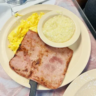 Two scrambled eggs, ham, and grits.