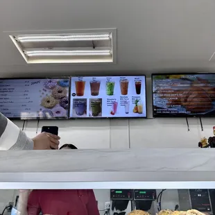 a woman taking a picture of a display of donuts
