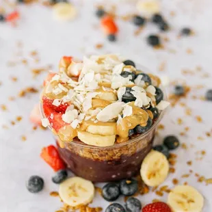 a bowl of oatmeal topped with bananas, strawberries, and blueberries
