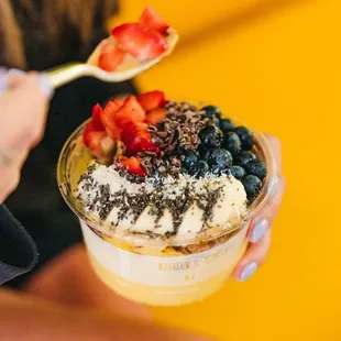 a woman eating a bowl of fruit