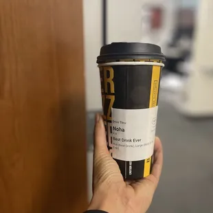 a hand holding a coffee cup