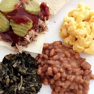 Pulled pork Sandwich with greens, baked beans, and macaroni. (I added pickles and cheese)