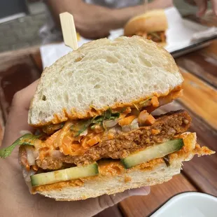 a person holding a sandwich in their hand